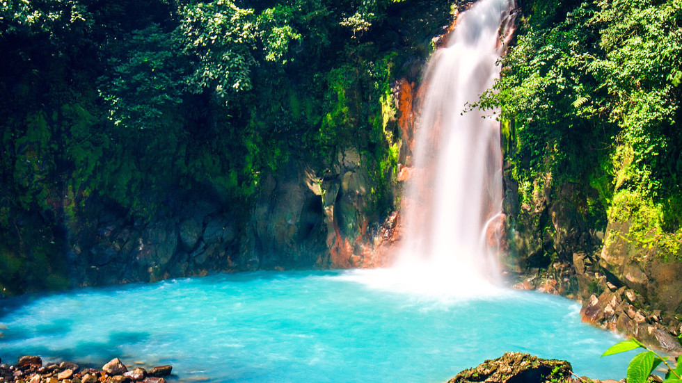 waterfall in green forest, small turquoise lake