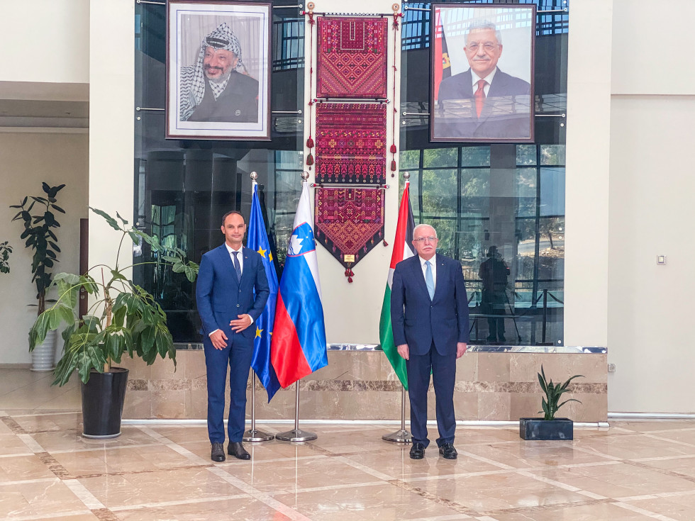 ministers in front of flags and portraits