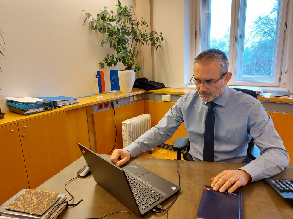 Igor Jukič sedi za mizo, gleda v računalnik