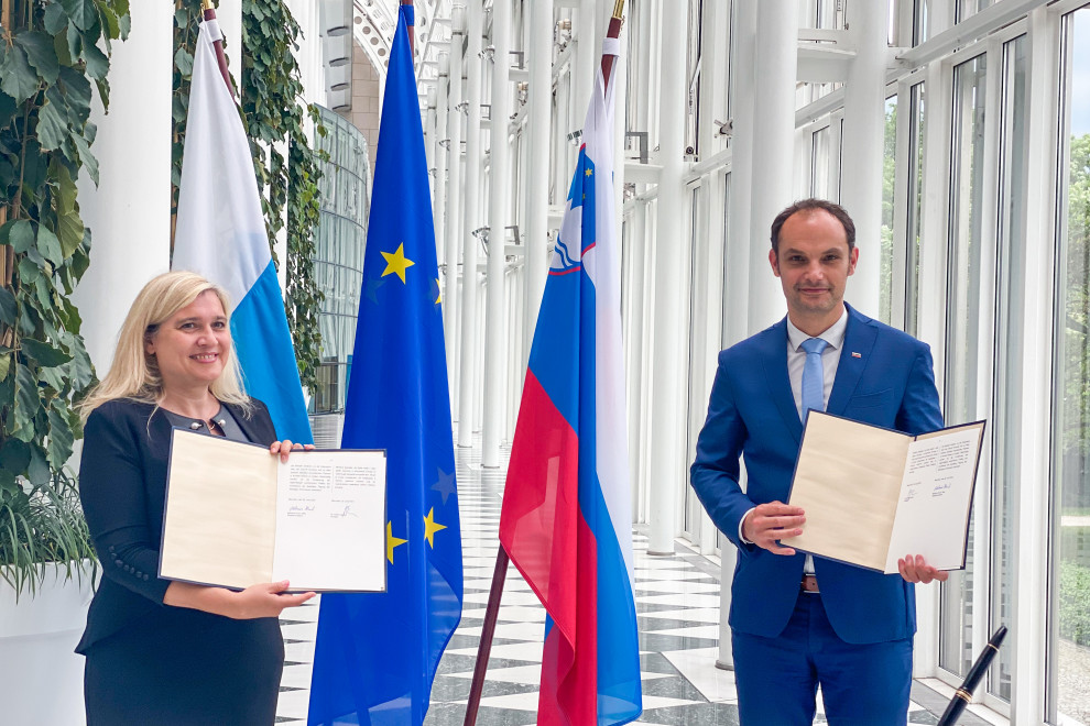 standing with documents in their hands, flags behind