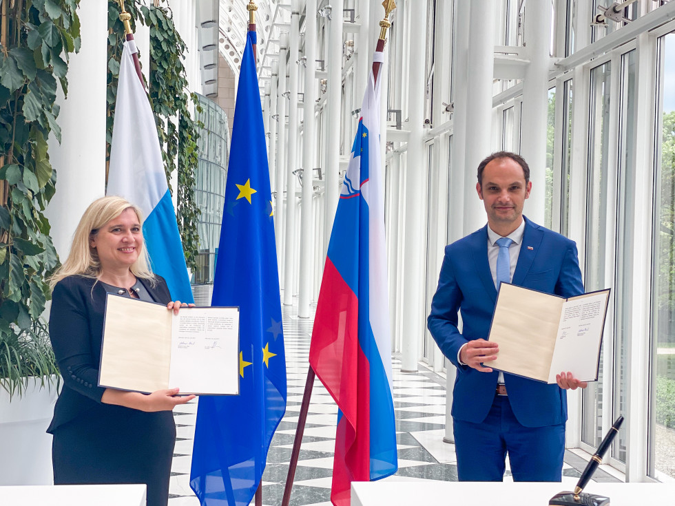 standing with documents in their hands, flags behind