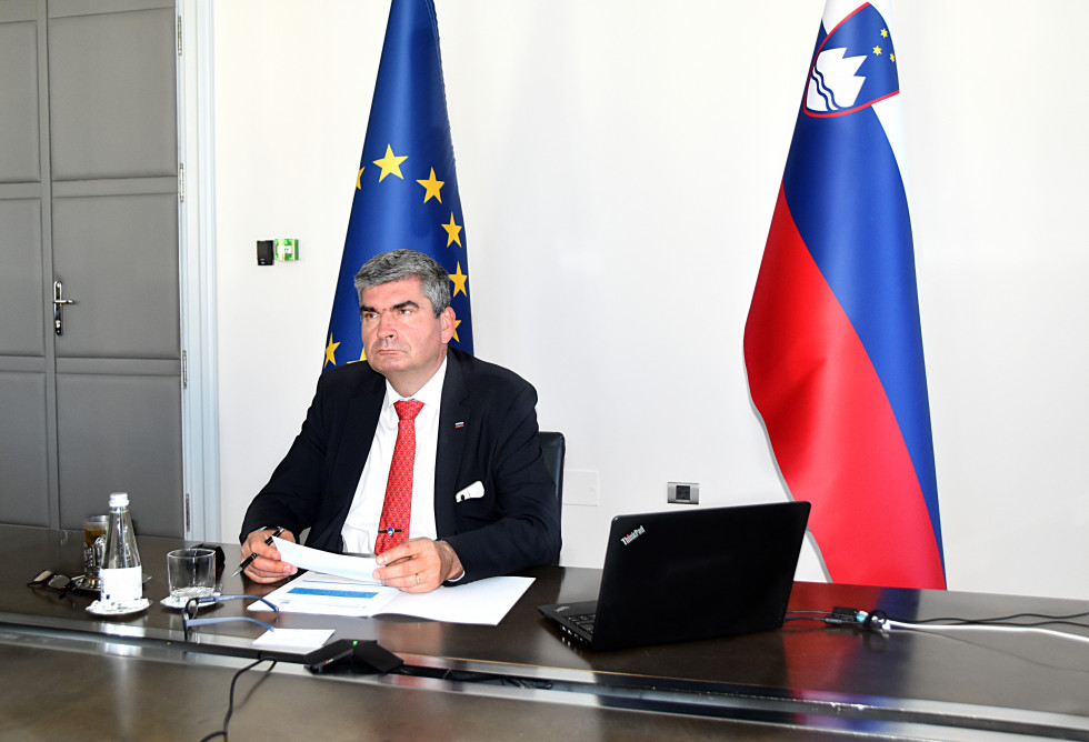 sitting at his desk, flags behind