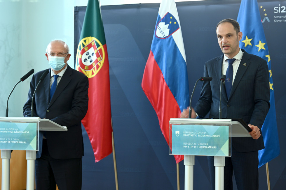 standing with flags behind 