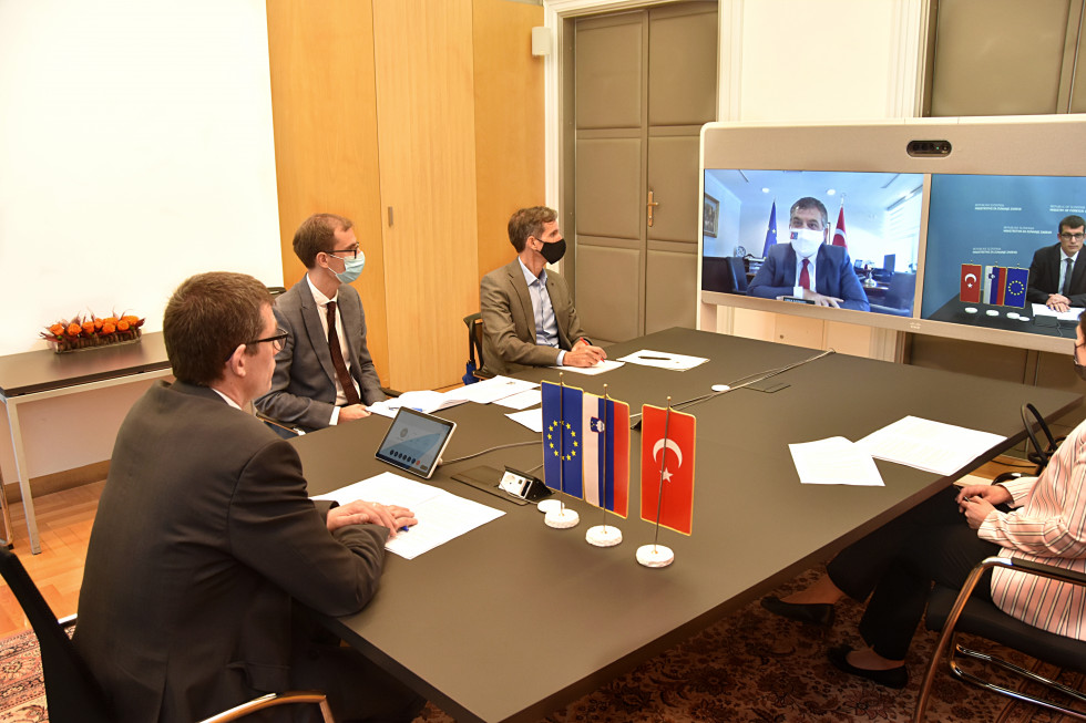 around the table with colleagues and computer screen with participants