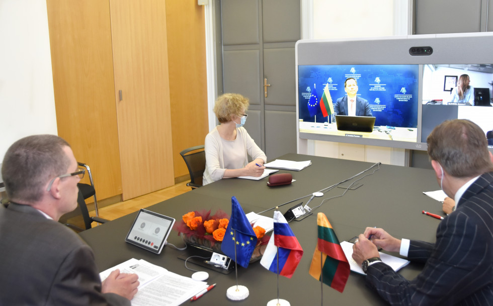 with colleagues at his desk, flags on the table