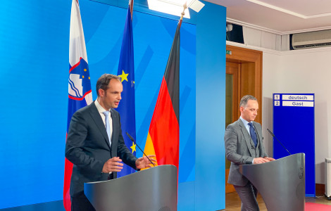 Maas Logar  tiskovna (press conference, standing with flags behind)