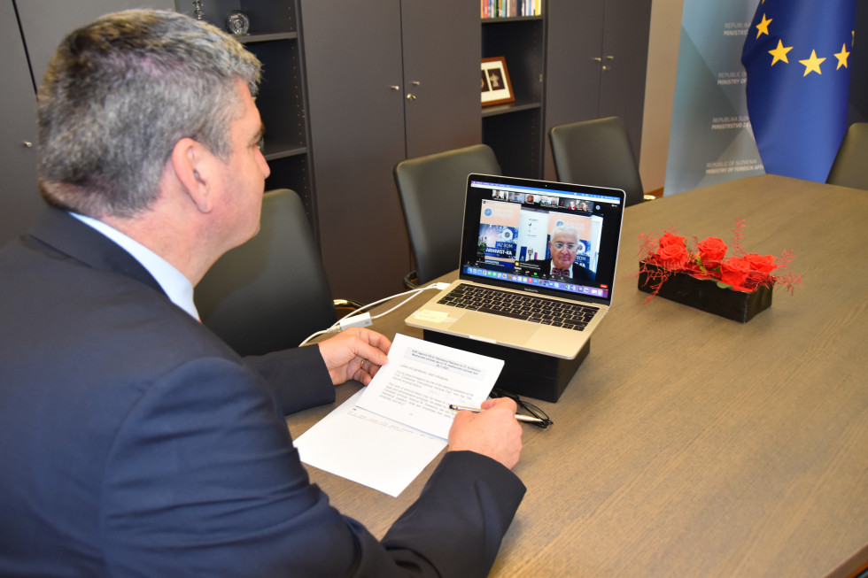 state secretary sitting, looking at the laptop, talking