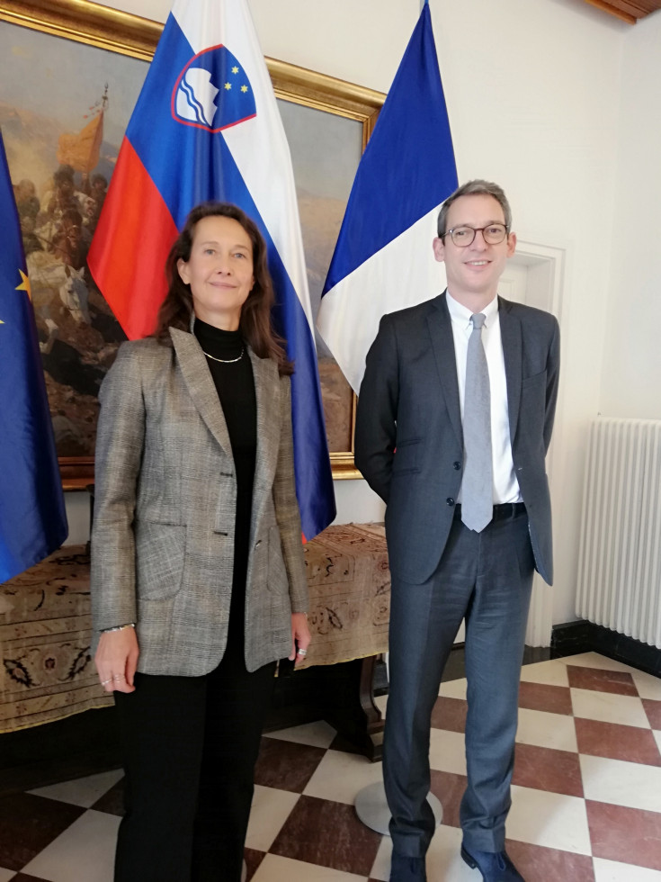 Generalna direktorica Barbara Sušnik direktor za EU v Ministrstvu za Evropo in zunanje zadeve Francije David Cvach pred evropsko, slovensko in francosko zastavo