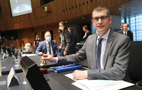 DS Dovzan pred zasedanjem FAC (Secretary of State sitting at a table, people in the background)