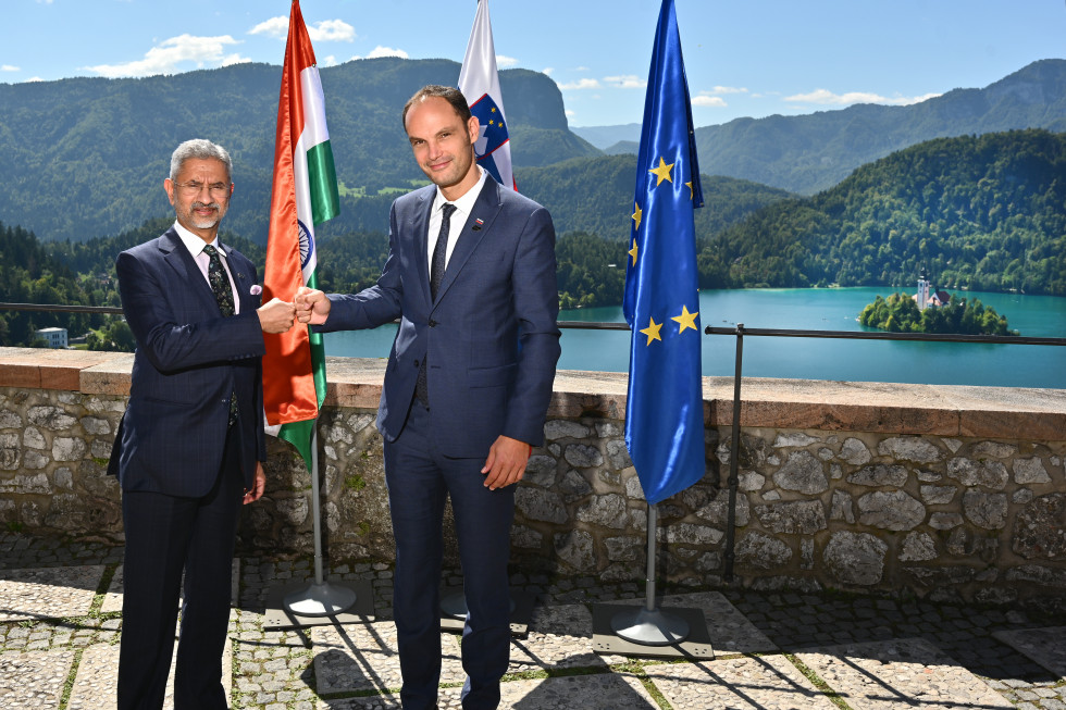 standing and shaking hands, with lake behind