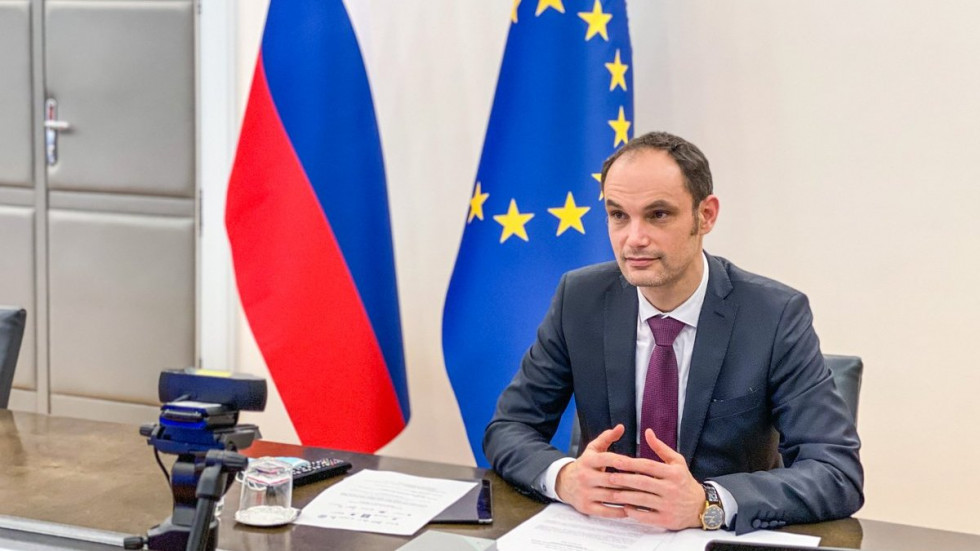 Dr. Anže Logar during the video conference, in the back Slovenian and European Union's flag