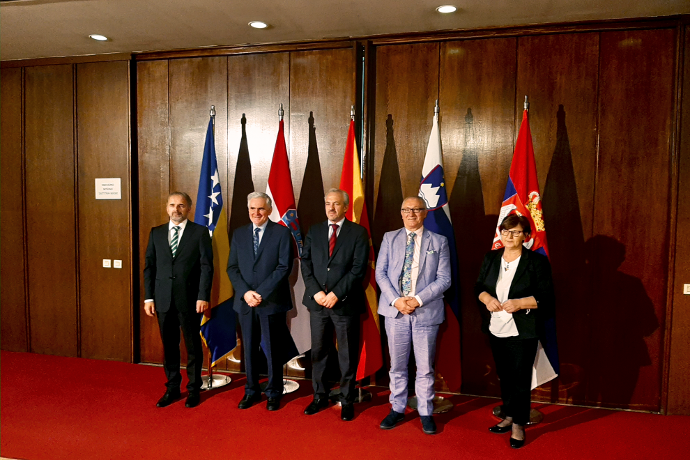 group photo of participants in front of flags