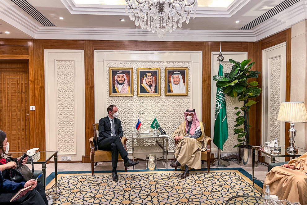 Bilateral meeting of the Slovenian and Saudi Foreign Ministers, sitting by the table, at tke back flags
