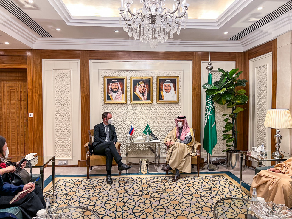 Dvostransko srečanje zunanjih ministrov Slovenije in Saudove Arabije, ministra med pogovorom sedita eden nasproti drugega, na mizici zastavici obeh držav