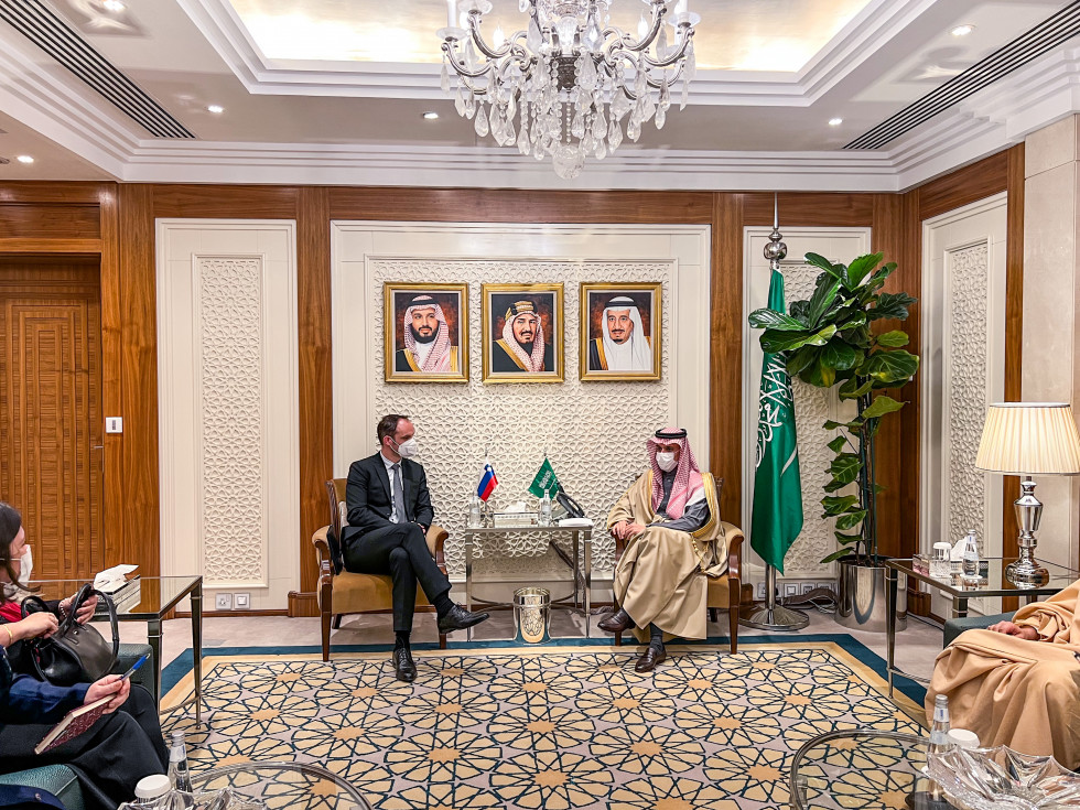 Bilateral meeting of the Slovenian and Saudi Foreign Ministers, sitting by the table, at tke back flags