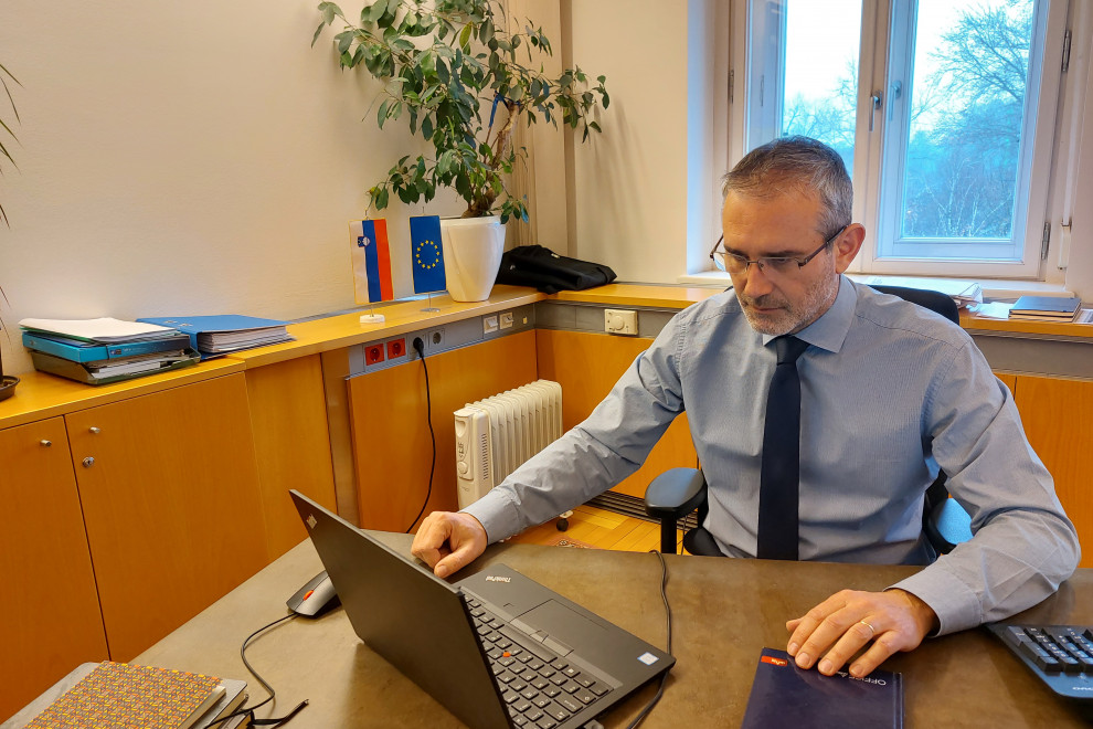 Igor Jukič sedi za mizo, gleda v računalnik