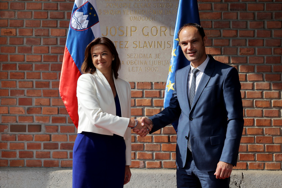 handshake between former minister Anže Logar and new minister Tanja Fajon