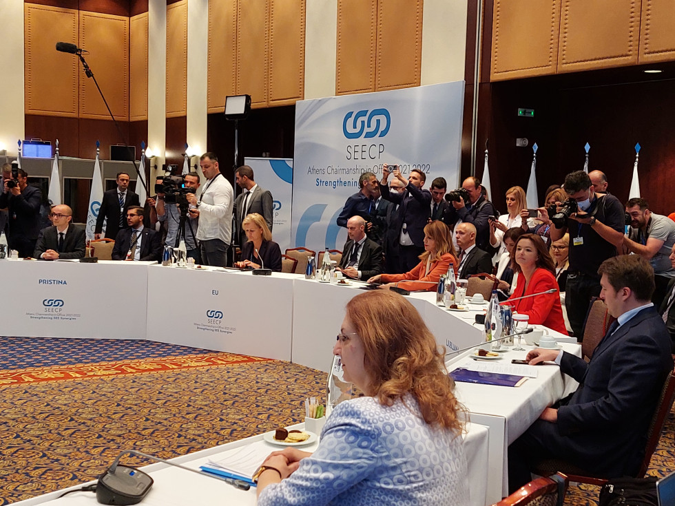 Meeting participants, including Tanja Fajon at the conference table, journalists and cameramen in the background