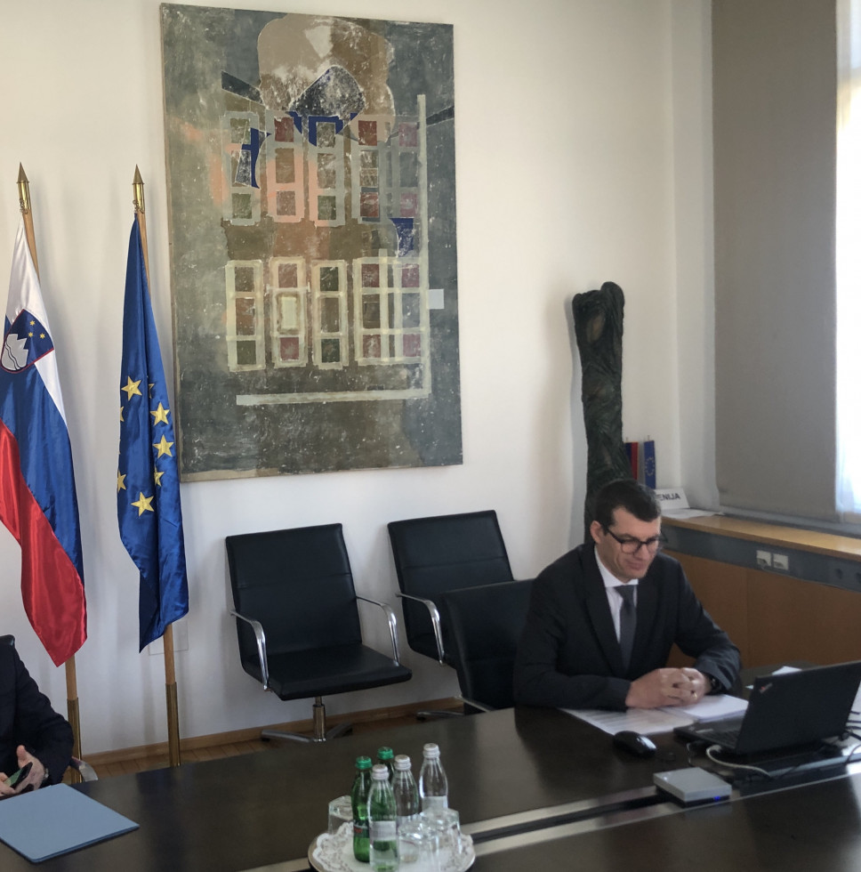 Državni sekretar Gašper Dovžan v pisarni pred računalnikom na video konferenci neformalnega zasedanja Sveta za splošne zadeve