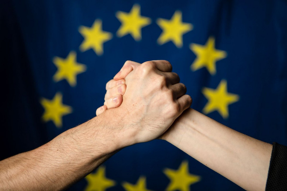stisnjeni roki pred evropsko zastavo