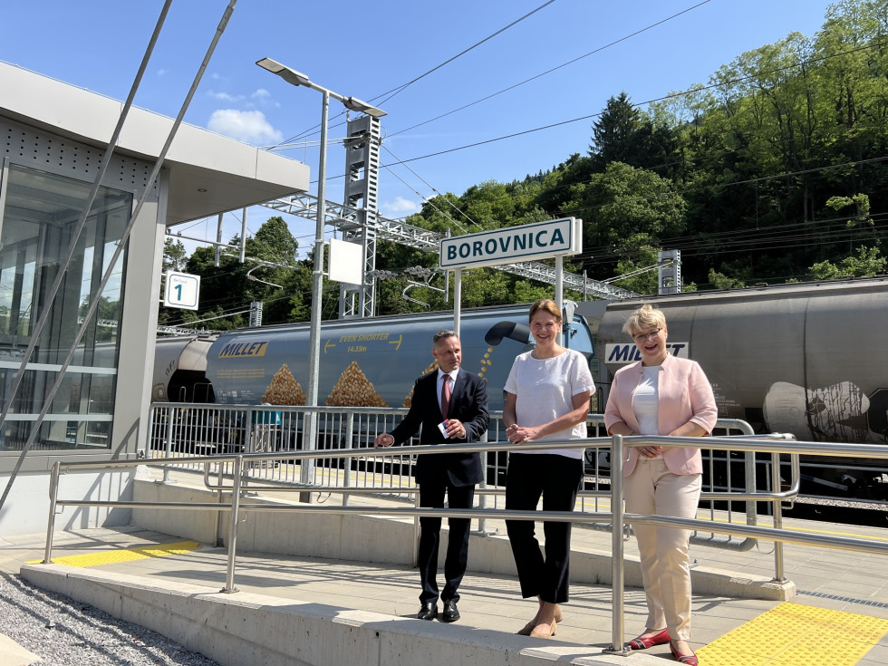 Ministrica za infrastrukturo Alenka Bratušek, vodja predstavništva Evropske komisije v Sloveniji Jerneja Jug Jerše ter župan Občine Borovnica Peter Črnilogar pod znakom z napisom Borovnica na železniki postaji Borovnica