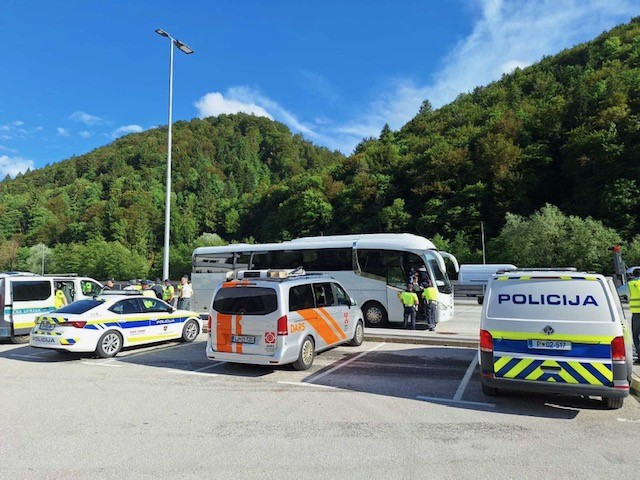 Na fotografiji avtobus ustavljen na počivališču, pred njim parkirana vozila DARS-a in Policije