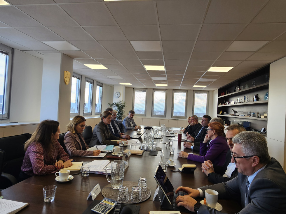 Ministrica z ekipo na eni strani velike sejne mize, na drugi pa predstavniki avtoprevoznikov, med drugim Peter Pišek.