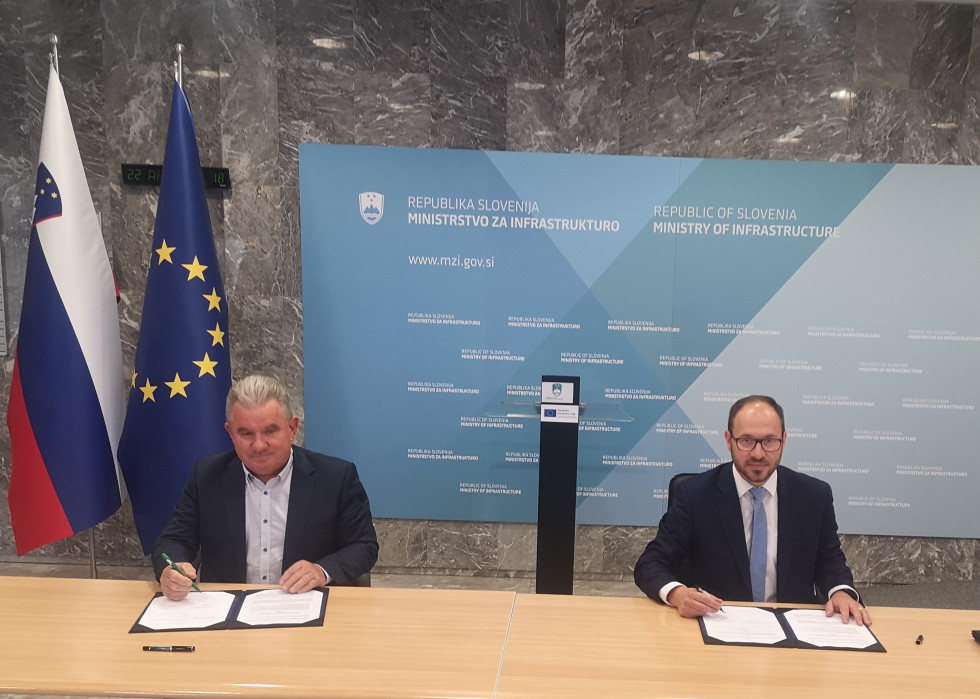 Minister Andrej Vizjak in minister Jernej Vrtovec za mizo v avli ministrstva ob podpisu pogodbe