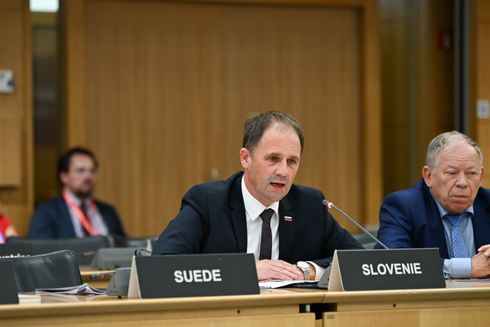 Moški na konferenci sedi za mizo.