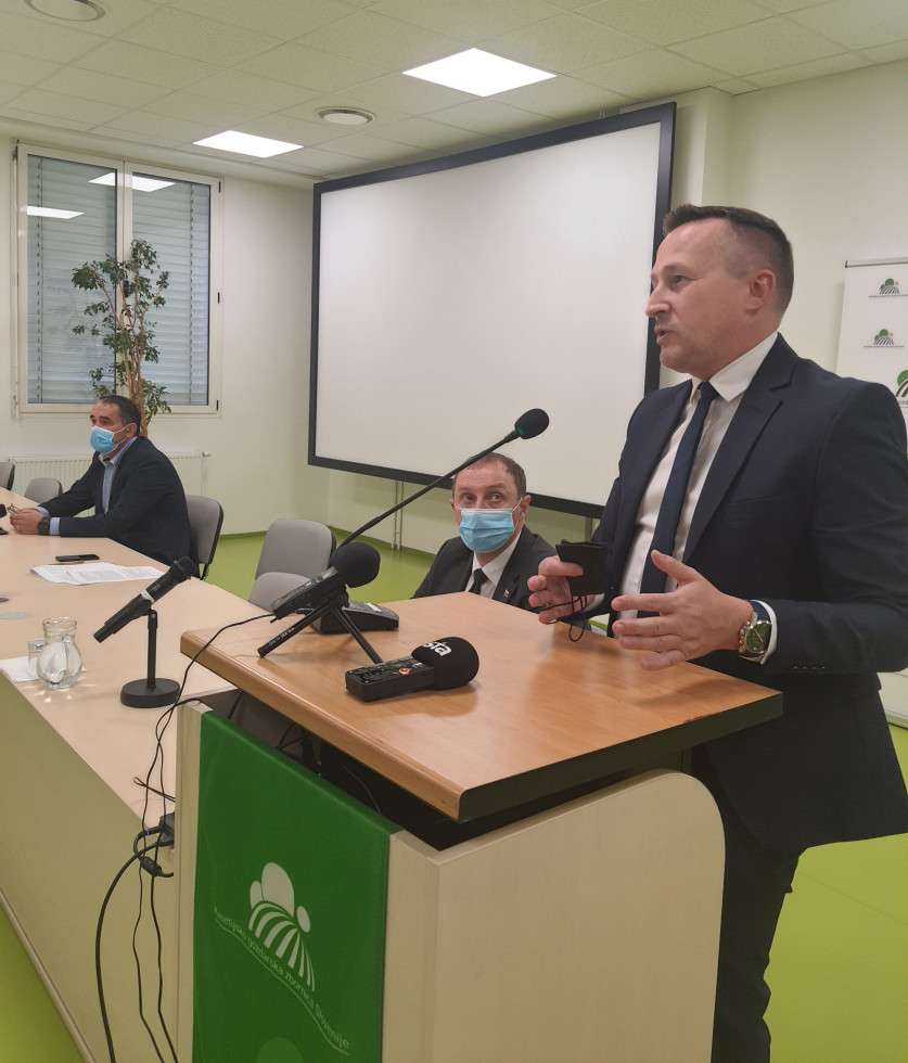 Generalni direktor ARSKTRP, mag. Miran Mihelič za govorniškim pultom, ob njemu na levi strani sedita direktor Kmetijsko gozdarske zbornice Slovenije in namestnik generalnega direktorja Agencije Republike Slovenije za kmetijske trge in razvoj podeželja.