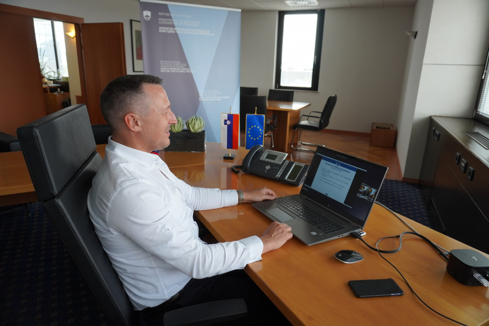 Generalni direktor ARSKTRP v pisarni pred ekranom se udeležuje virtualni konferenci 