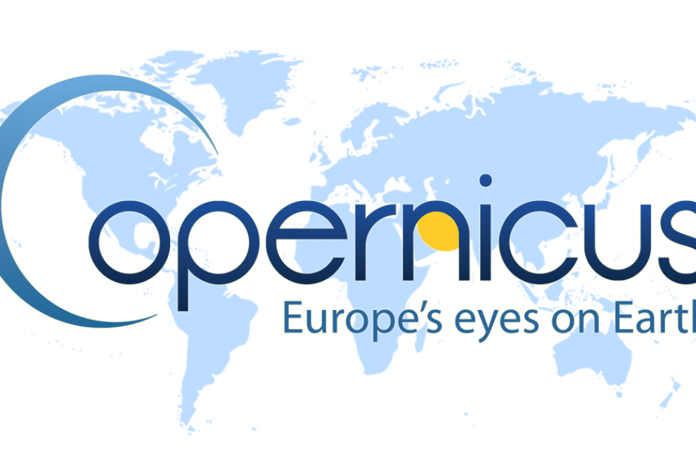 Logotip programa Copernicus, ki prikazuje zemljevid sveta. Celine so obarvane svetlo modro, oceani in morja z belo. Čez zemljevid je napis Copernicus in angleški prevod izreka Evropske oči na zemljo.