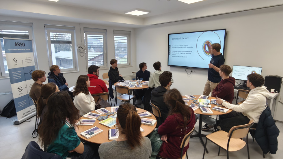 Profesor v učilnici predava dijakom za štirimi omizji