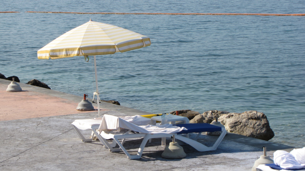 slika je simbolična. Morje, betonska plaža, ležalnika.