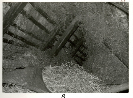 Črno-bela fotografija skrivališča Janeza Rusa v seniku nad domačim hlevom.
