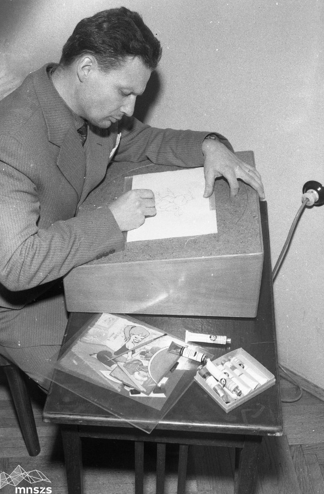 Črnobeli posnetek umetnika med risanjem.