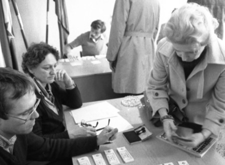 Black-and-white photograph of elderly people receiving vouchers.