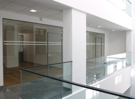 The modern extension is a mix of glass surfaces and concrete. 