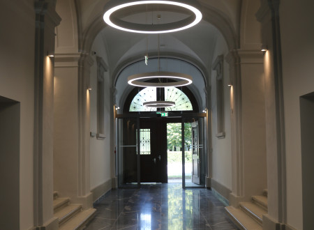 A darkened room with light filtering in through the open front door.