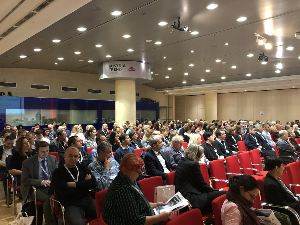 Visitors of the conference sitting in the conference hall. 