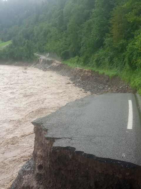 Popolnoma uničena cesta zaradi spodjedanja vode.