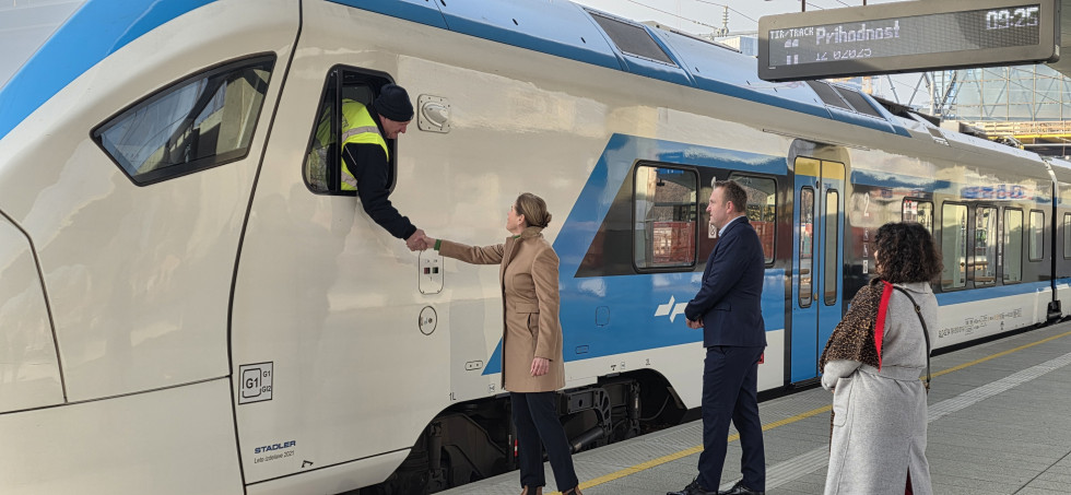 na sliki je vlak na novem peroni na železniški postaji Ljubljana. Rokujeta se strojevodja in ministrica Alenka Bratušek.