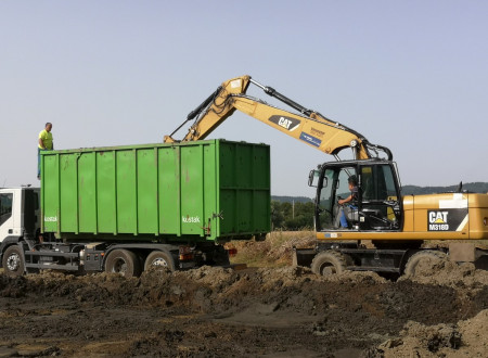 Gradbeni mehanizirani stroj naklada zemljo na tovornjak