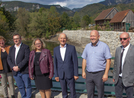 Ljudje stojijo pred visokim zidom