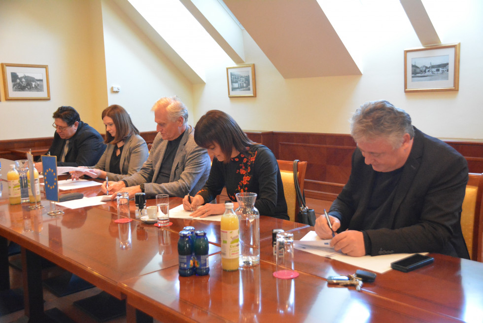 Direktor Direkcije Republike Slovenije za vode in župani sedijo za mizo in podpisujejo sporazume