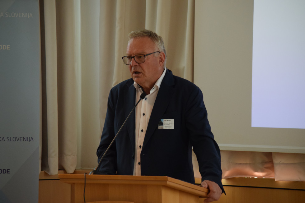 Minister Jože Novak ob uvodnem nagovoru stoji za govorniškim pultom
