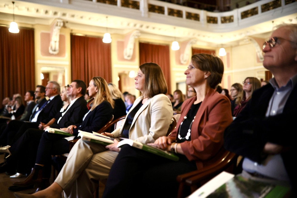 Udeleženci srečanja sedijo na stolih ter poslušajo prestavitve. Slikana je prva vrsta, kjer sedita v.d. direktorja dr. Lidija Kegljevič Zagorc ter Neža Kodre.