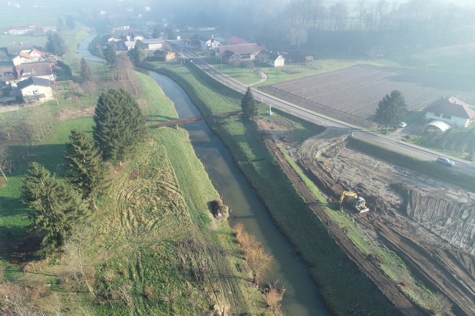 Fotografija iz zraka. Travnik, reka, gradnja nasipov. 