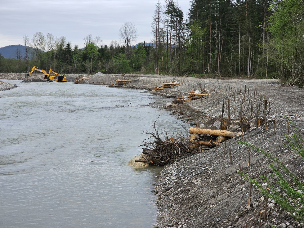 Kašte na vodotoku, v ozadju dva bagra v vodotoku pri delu.