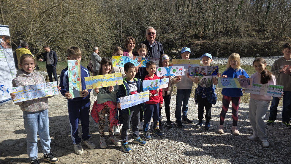 Minister Jože Novak and Director of the Water Institute Neža Kodre with students from France Bevk Primary School Tolmin, who are holding the drawings thez made in their arms
